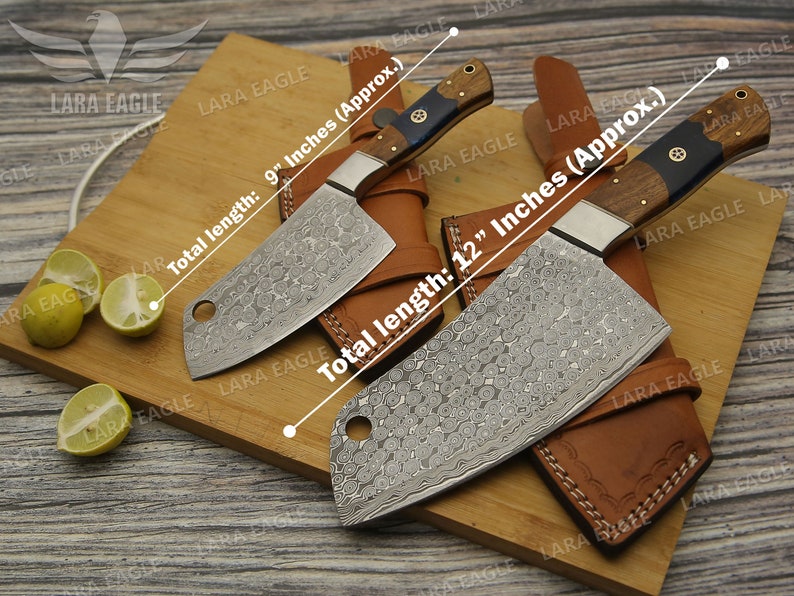 May include: Two cleavers with leather sheaths on a wooden cutting board. The cleavers have a hammered finish and wooden handles. The cleavers are 9 inches and 12 inches long.