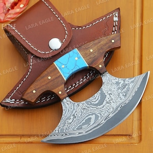 May include: A handmade Damascus steel throwing knife with a blue and brown handle. The knife is in a leather sheath.