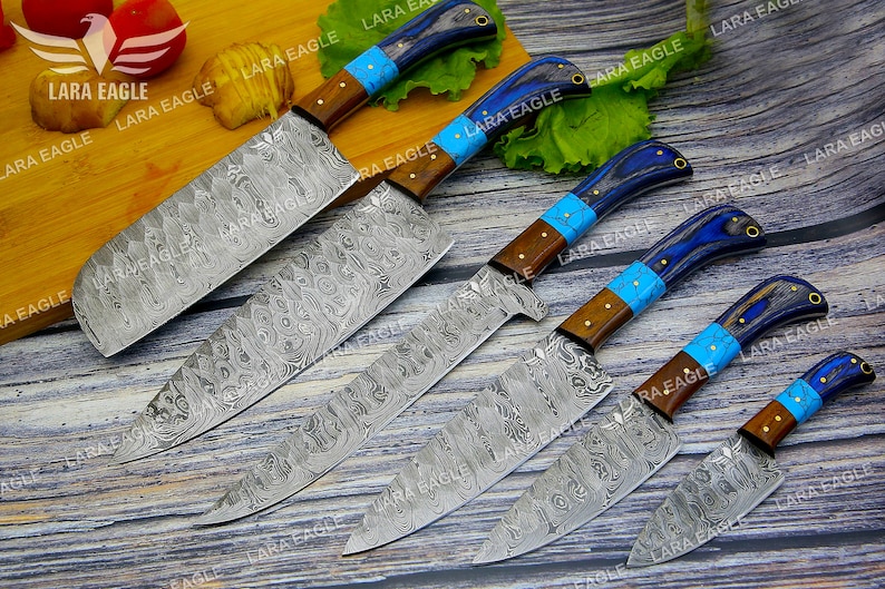 May include: Set of six kitchen knives with blue and brown handles. The blades are made of Damascus steel and have a wavy pattern.