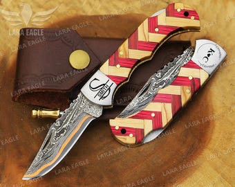 May include: A personalized pocket knife with a Damascus steel blade and a red and wood patterned handle. The knife is engraved with the name "Smith" and the initials "S" and "S". The knife also has a small pocket clip and a leather sheath.