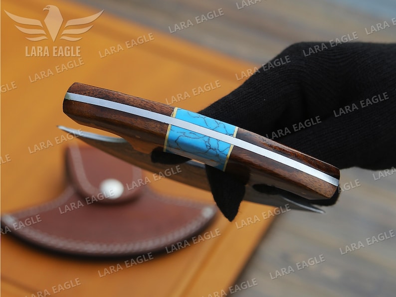 May include: A brown and silver folding knife with a turquoise inlay. The knife has a leather sheath.