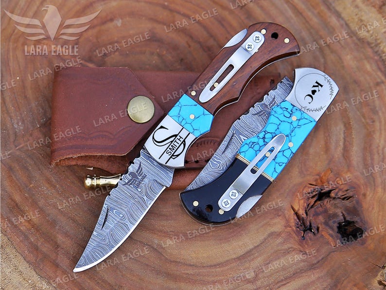 May include: Two personalized pocket knives with turquoise inlays and Damascus steel blades. One knife has the name "Smith" engraved on it, and the other has the initials "K.C." engraved on it.