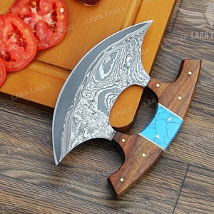 May include: A curved, stainless steel knife with a blue and brown wooden handle. The knife has a unique, patterned blade and is designed for chopping and slicing.