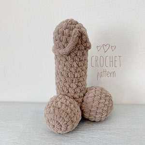 Könnte beinhalten: Ein gehäkeltes Plüschspielzeug in Form eines menschlichen Körperteils. Das Spielzeug ist braun und hat eine strukturierte Oberfläche. Das Bild enthält den Text "CROCHET pattern".