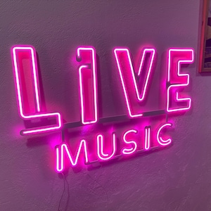 Może przedstawiać: Różowy neonowy znak z napisem "LIVE" dużymi literami i "MUSIC" mniejszymi literami poniżej.
