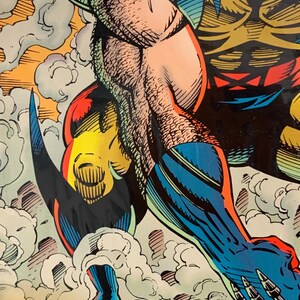 Pu&ograve; includere: Illustrazione di fumetti con un supereroe in azione. Il personaggio indossa un costume blu e giallo, con muscoli dettagliati e linee di azione. L'opera d'arte include il testo "ann nocenti".