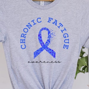 Könnte beinhalten: Graues T-Shirt mit einem blauen Band und dem Aufdruck "Chronic Fatigue Awareness".