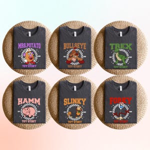 May include: Six dark grey t-shirts featuring Toy Story characters: Mrs. Potato Head, Bullseye, Rex, Hamm, Slinky, and Forky. Each shirt has a character graphic with the text "TOY STORY" and the character's name in a circle.