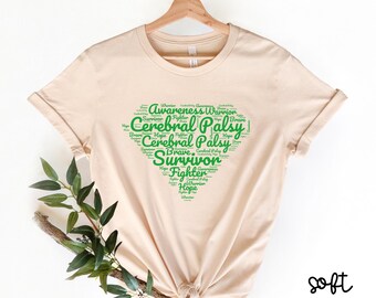 May include: A soft cream coloured t-shirt with a green heart-shaped word cloud design. The words in the cloud include "Cerebral Palsy", "Survivor", "Hope", "Warrior", "Fighter", and "Brave".