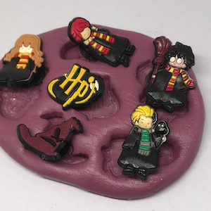 May include: Silicone mold with seven cavities for making Harry Potter themed cake decorations. The mold features a Hogwarts crest, a sorting hat, and five characters: Harry Potter, Ron Weasley, Hermione Granger, Draco Malfoy, and Neville Longbottom.