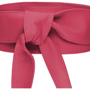 Könnte beinhalten: Ein rosa Ledergürtel mit einem langen Band, das zu einer Schleife gebunden werden kann. Der Gürtel ist aus weichem, geschmeidigem Leder gefertigt und hat ein schlichtes, elegantes Design.