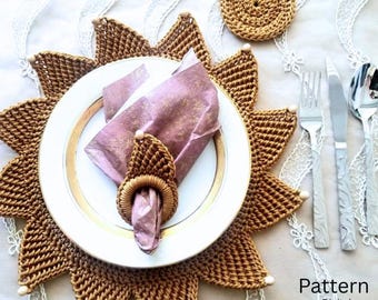 May include: A crochet sun-shaped placemat in golden brown with a matching coaster, a white plate with a gold rim, a mauve napkin, and a crochet napkin ring. Silverware includes a fork, knife, and spoon. Text reads: Pattern Digital Download.