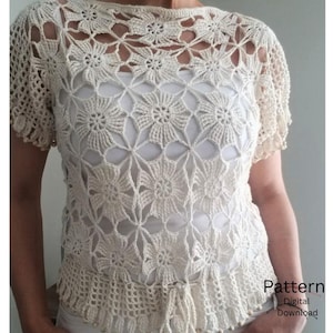 Könnte beinhalten: Ein cremefarbenes Häkeloberteil mit einem sich wiederholenden Blumenmuster, kurzen Ärmeln und einem zarten Netzsaum. Das Kleidungsstück verfügt über ein Taillenband mit Kordelzug und ist mit dem Text Pattern Digital Download versehen.