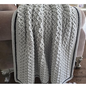 May include: A light gray crochet blanket featuring a textured diamond stitch pattern. The blanket has a border with thin black and white stripes. The text Pattern Digital Download PDF is visible in the bottom right corner of the image.