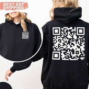 May include: Black hoodie with a white QR code printed on the back. The hoodie has a drawstring hood and a kangaroo pocket.