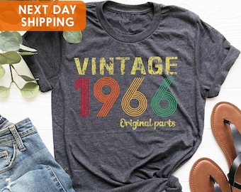 May include: A dark gray t-shirt with the text "Vintage 1966 Original parts" in colorful retro-style font.