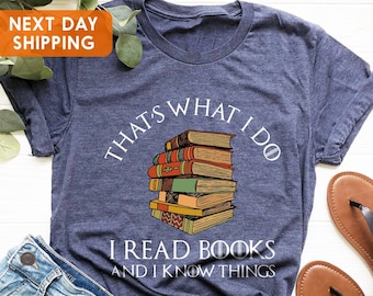 May include: A navy blue t-shirt with a stack of books and the text "That's what I do I read books and I know things".
