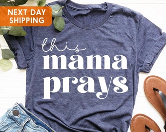 May include: A navy blue t-shirt with the text "this mama prays" in white lettering.