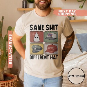 May include: A beige t-shirt with the text "SAME SHIT DIFFERENT HAT" and four images of different hats. The shirt also has the text "BELLA+CANVAS" on the side and "NEXT DAY SHIPPING" at the top.