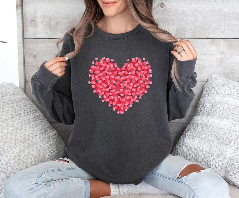 May include: A dark gray sweatshirt with a large red heart made of smaller hearts printed on the front.
