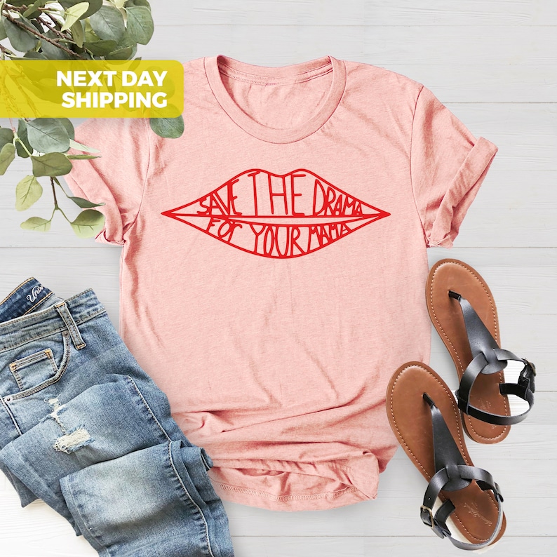 K&ouml;nnte beinhalten: Ein rosa T-Shirt mit einem roten Umriss einer Lippenpartie. Der Text innerhalb der Lippen lautet "Save the drama for your mama."