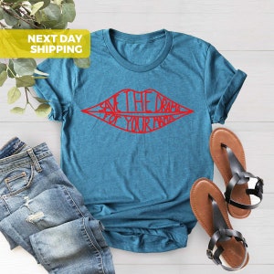 K&ouml;nnte beinhalten: Ein t&uuml;rkisfarbenes T-Shirt mit einer roten Grafik von Lippen mit dem Text "Save the drama for your mama" darin.