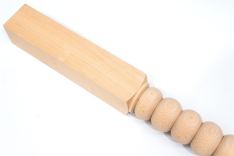 May include: A wooden table leg with a square top and a rounded bottom with a series of decorative beads.