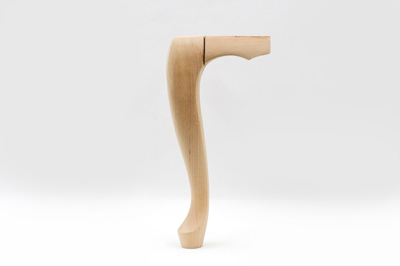 May include: A wooden chair leg with a curved design. The leg is unfinished and has a natural wood color.