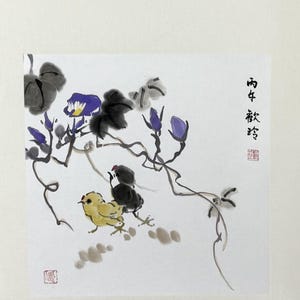 May include: A traditional ink wash painting on white paper featuring two small chicks, one yellow and one black, positioned beneath a flowering vine with purple blossoms and dark grey leaves. Black Chinese calligraphy and red stamps are visible.