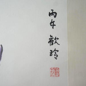 May include: A painting on off-white paper featuring purple flower buds with dark gray stems. The artwork includes vertical black Chinese calligraphy characters and a small square red seal stamp at the bottom right corner of the composition.