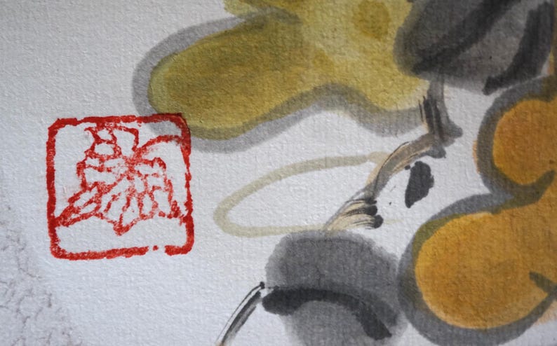 May include: Close-up of a watercolor painting featuring abstract floral elements. The artwork showcases a red square stamp with a floral design, alongside yellow, gray, and black brushstrokes on a white background.