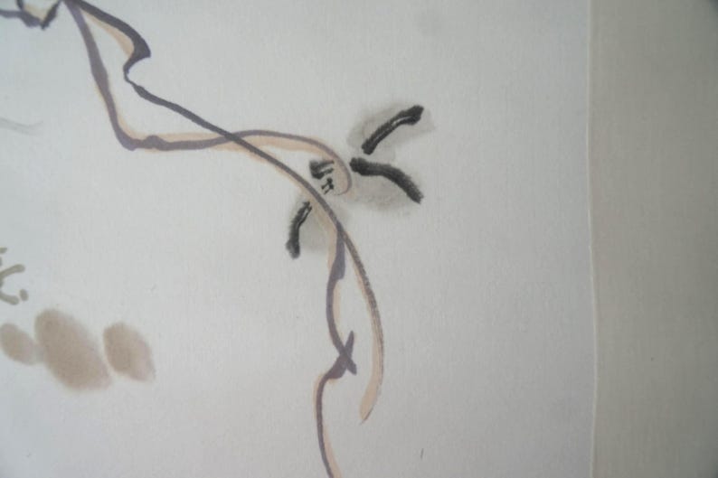 May include: A minimalist ink wash painting on off-white paper featuring fluid, thin black and brown lines that form abstract, organic shapes. The composition includes delicate brushstrokes and soft, muted brown ink splatters across the surface.
