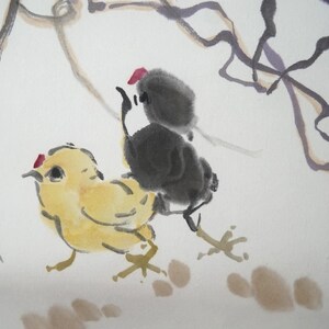 May include: An ink and watercolor painting on paper featuring a yellow chick and a black chick standing together. The yellow chick has a small red crest, and the black chick is positioned behind it. Thin, dark, flowing lines suggest branches above.