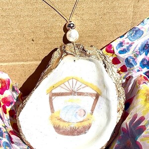 Decorazione natalizia di Gesù Bambino. Decorazione natalizia a forma di conchiglia di Gesù Bambino. Decorazione religiosa. Decorazione della Natività di Gesù Bambino. Dono di Cristo.