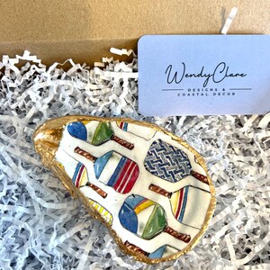 multicolor pickleball paddle design on an oyster shell ring dish