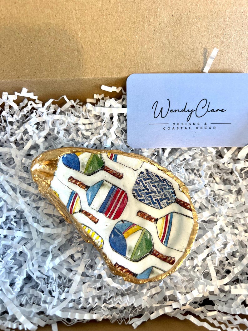 multicolor pickleball paddle design on an oyster shell ring dish