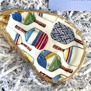 multicolor pickleball paddle design on an oyster shell ring dish