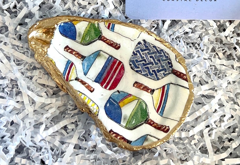 multicolor pickleball paddle design on an oyster shell ring dish