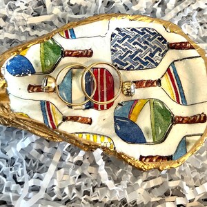 multicolor pickleball paddle design on an oyster shell ring dish