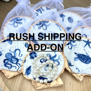 May include: White and gold seashell-shaped dishes with blue sea creature designs, including octopuses and starfish. A pearl bracelet rests in one dish. The text "RUSH SHIPPING ADD-ON" is displayed.