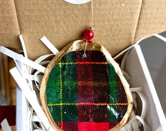 May include: A handmade Christmas ornament with a gold-painted edge and a plaid fabric center in red, green, and yellow. The ornament hangs from a gold string with a red bead. The packaging includes a thank you sticker from Wendy Clare Designs.