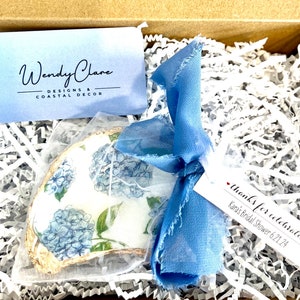 Könnte beinhalten: Eine blaue und weiße Austernschalen mit einem Blumenmuster, gebunden mit einem blauen Band und einem Dankes-Etikett mit der Aufschrift "Danke fürs Feiern von Karas Bridal Shower 6.21.24".