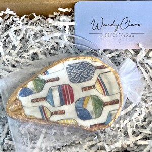 multicolor pickleball paddle design on an oyster shell ring dish