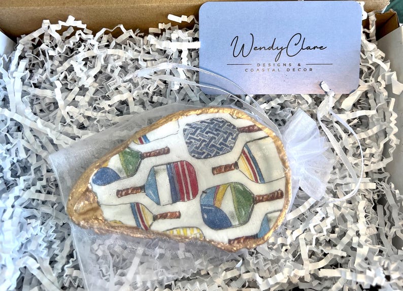 multicolor pickleball paddle design on an oyster shell ring dish