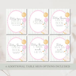 May include: Set of six party signs with a whimsical goose theme. Each sign features a pink oval frame with text like "Photo Booth" and "Favors." The signs include illustrations of a goose with balloons and text on a striped background.