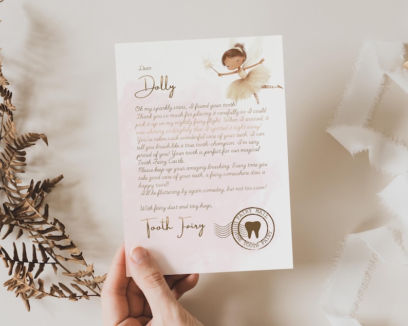 Pode incluir: Uma carta da Fada do Dente endere&ccedil;ada a "Dolly" com uma ilustra&ccedil;&atilde;o de fada. A carta inclui texto sobre encontrar um dente e um Castelo da Fada do Dente. Um selo da Fada do Dente tamb&eacute;m &eacute; vis&iacute;vel.