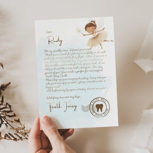 Pode incluir: Uma carta da Fada do Dente endere&ccedil;ada a Rudy, com uma ilustra&ccedil;&atilde;o de fada e um selo em forma de dente. O texto da carta inclui frases como "estrelas brilhantes" e "voo de fada".