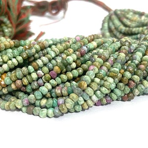 May include: Multiple strands of green and pink gemstone beads. The beads are small, round, and faceted, with a mix of green and pink hues. The beads are strung together, forming multiple strands. The background is white.