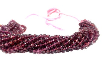 May include: A strand of faceted, deep burgundy beads. The beads are strung together, forming multiple strands. The beads are a rich, dark red-purple color. The background is white, highlighting the beads.