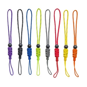 Puede incluir: Conjunto de ocho llaveros de paracord de colores con un diseño trenzado y una pequeña cuenta de metal en la parte superior.